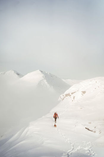 Man skiing on snowcapped mountain against sky