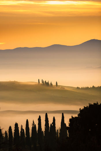 Silhouette mountains against orange sky