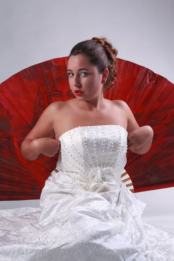 Portrait of young woman in dress against white background