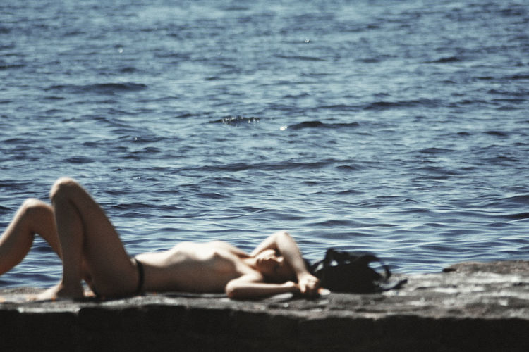 Low section of woman relaxing in sea