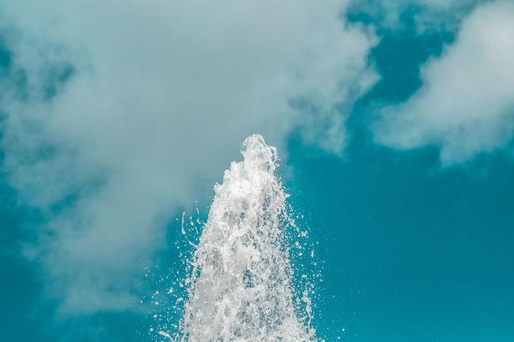 Close-up of water splashing in sea against sky