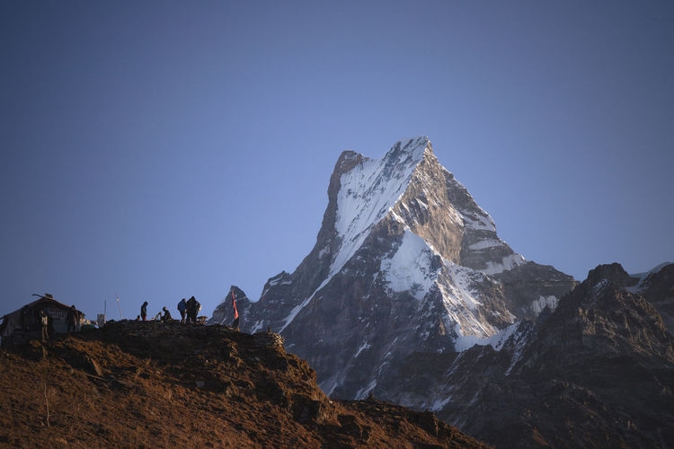 Scenic view of snowcapped mountains against clear blue sky