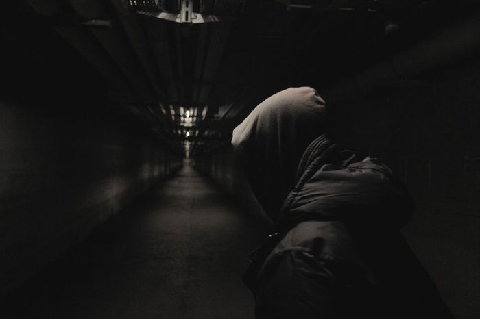 Hooded man in dark corridor