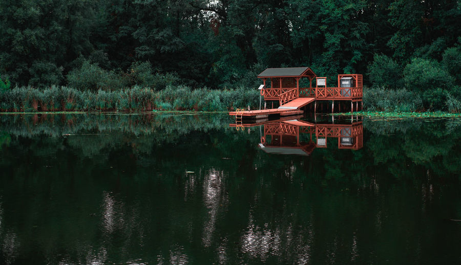 Built structure by lake against trees
