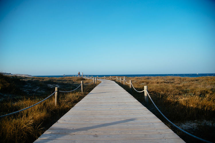 View of beach against clear blue sky