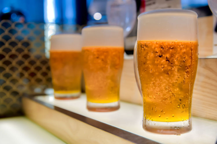 Close-up of beer glasses on table