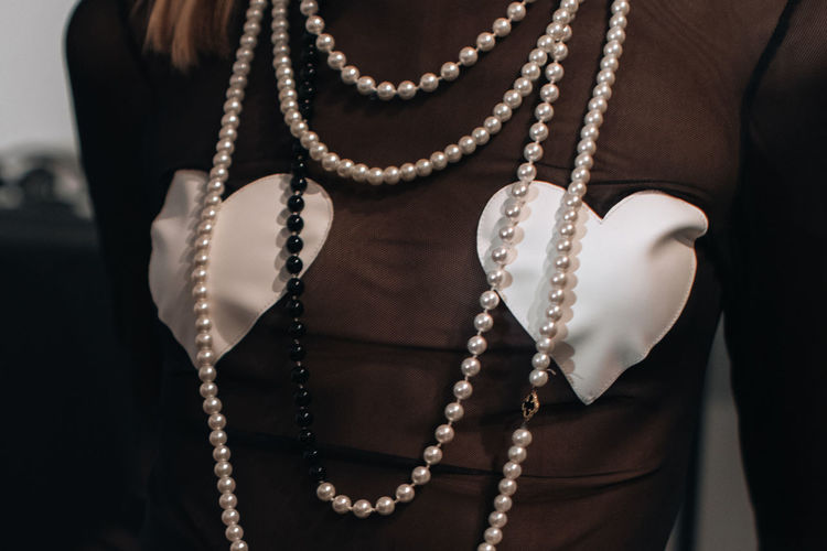 Midsection of woman with pearl jewelry