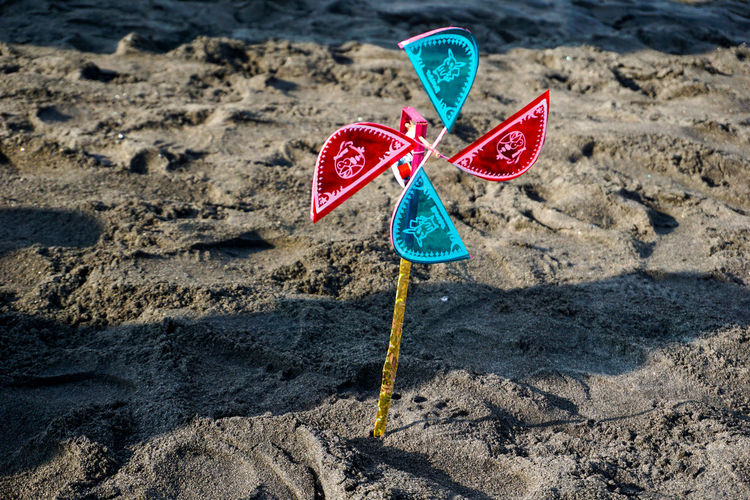 Close-up of pinwheel toy on sand at beach