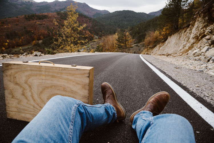 Low section of man relaxing on road