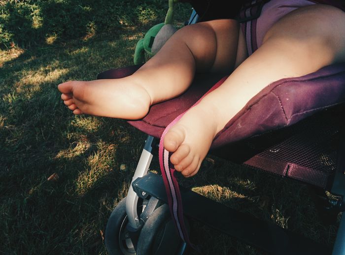 Low section of girl sitting in grass