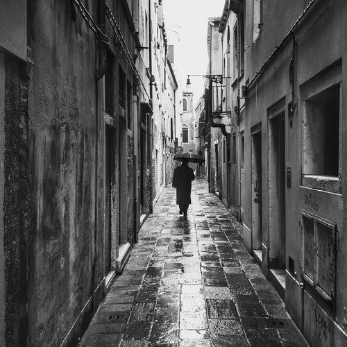 Rear view of man walking in alley