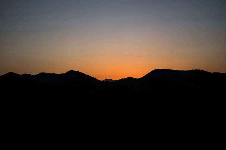 Silhouette mountains against sky during sunset