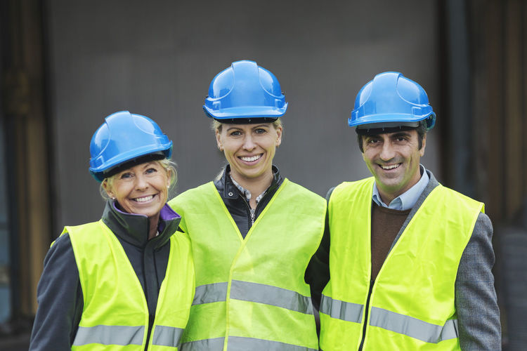 Portrait of confident workers in protective clothing at factory