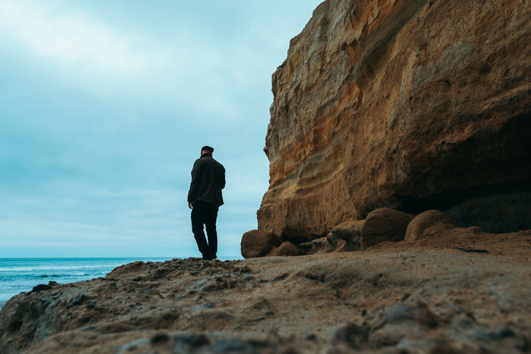 Man standing on rock against sea