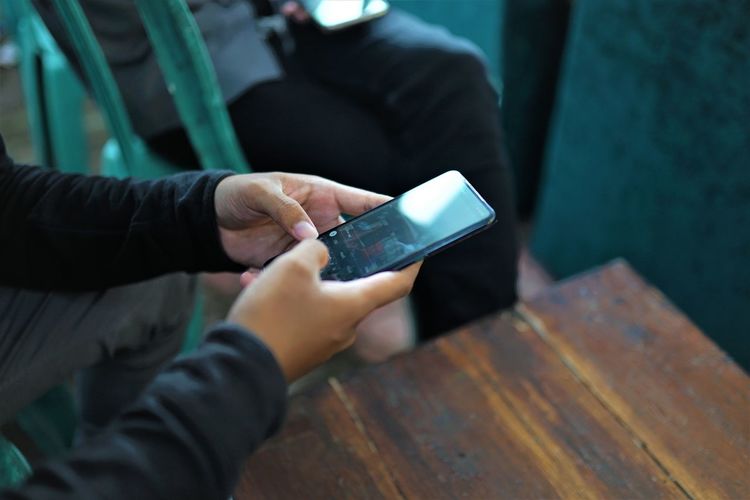Midsection of man using mobile phone
