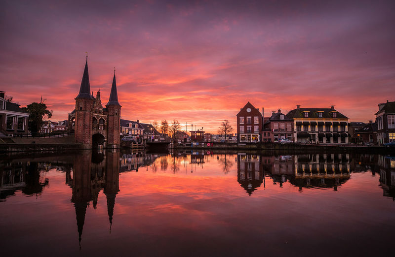 Reflection of buildings in river during sunset
