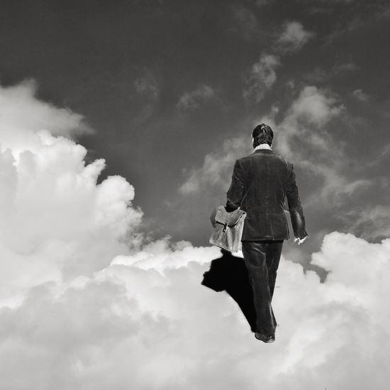 Low angle view of woman standing against cloudy sky