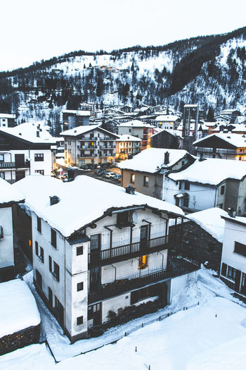High angle view of snow covered houses and buildings in city