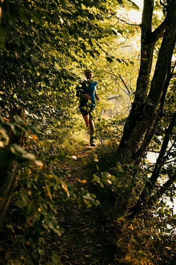 Full length of man running amidst plants