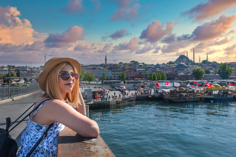 Young woman in sunglasses against cityscape in city