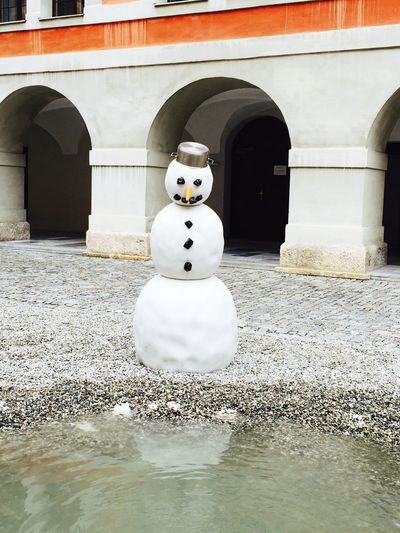 Snowman against building