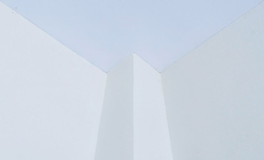 High section of white built structure against sky