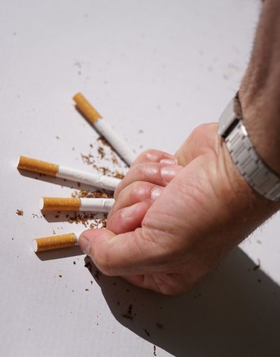 Close-up of hand crushing cigarettes