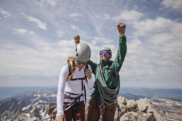 Smiling couple celebrates reaching the summit of the grand teton
