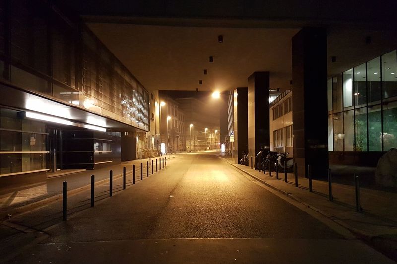 Illuminated corridor in city at night