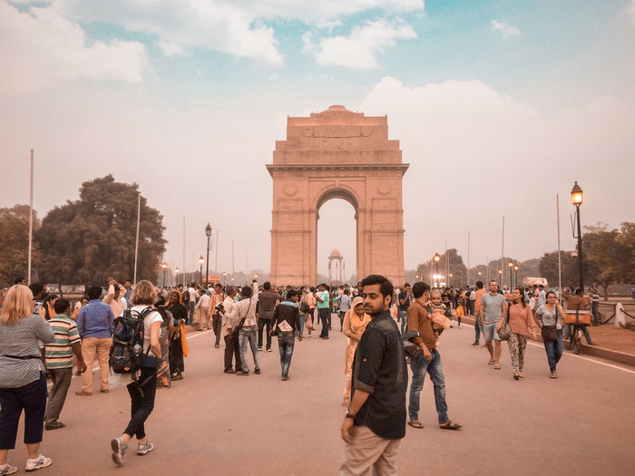 Man walking against india gate during sunset