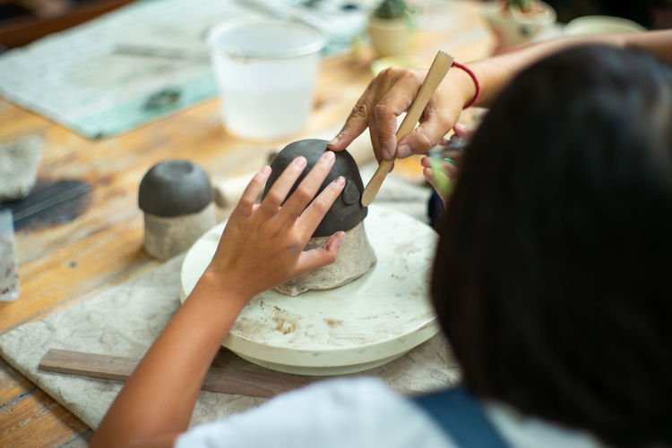 Cute girl making pottery at school