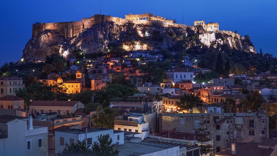 Buildings against acropolis of athens at night