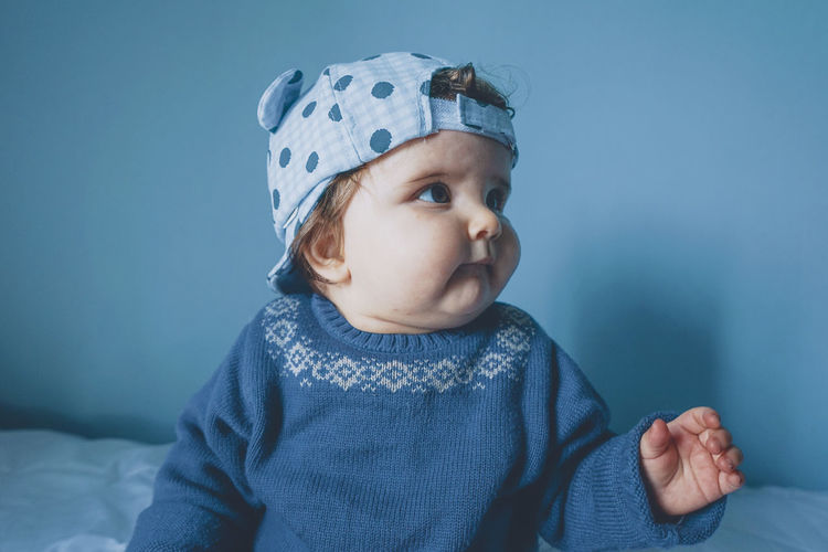 Close-up of baby girl wearing cap at home