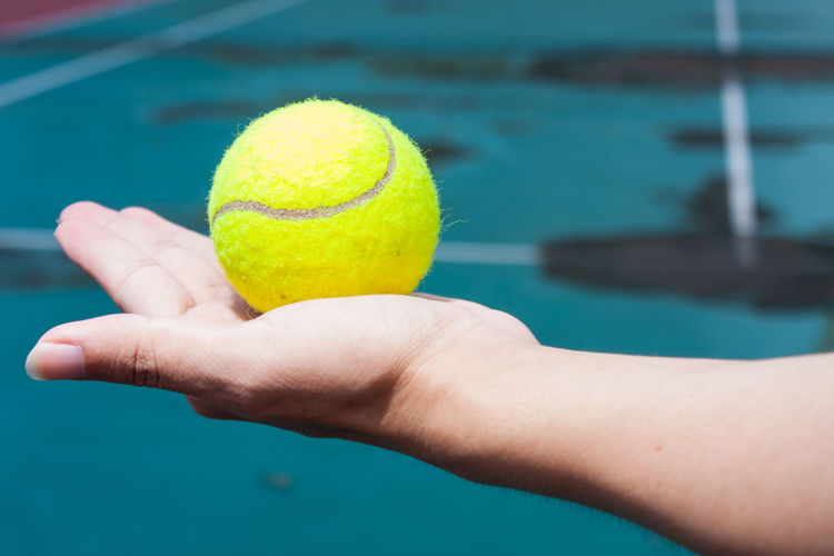Close-up of woman hand holding tennis ball