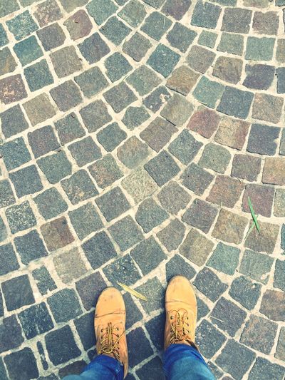 Low section of man standing on cobblestone