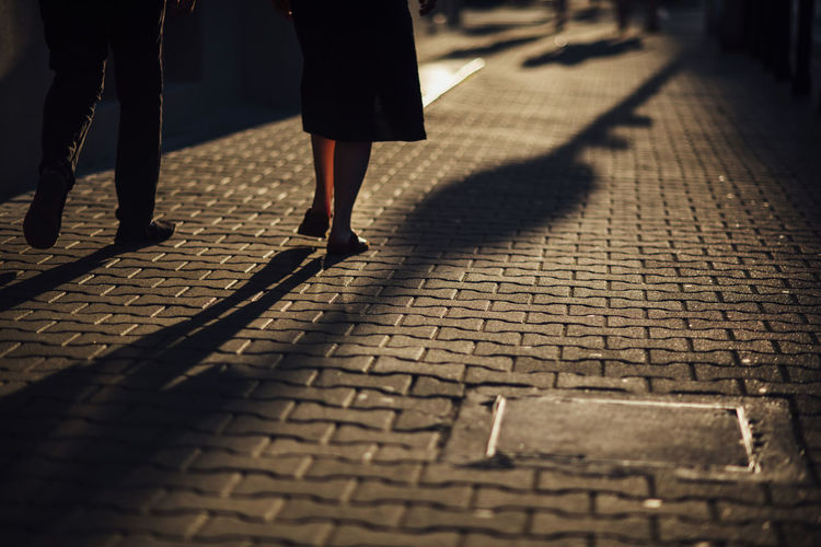 Low section of people walking on street