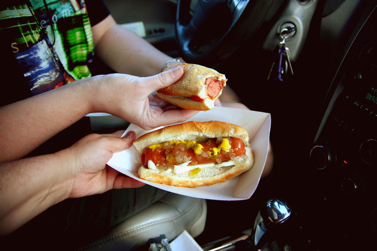 Close-up of hands holding hot dogs