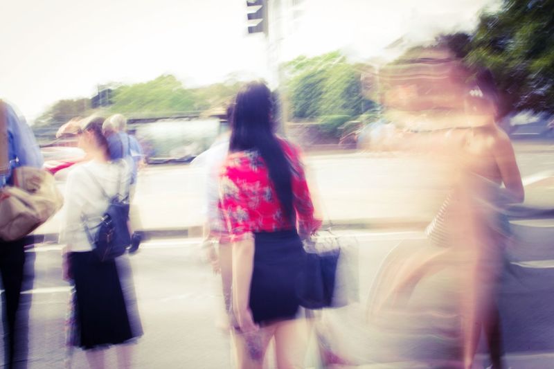 Rear view of women walking on road in city