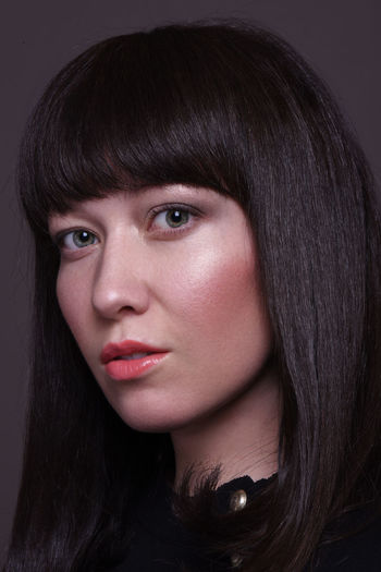 Close-up portrait of woman with bangs wearing make-up