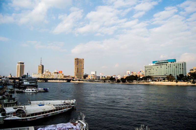 High angle view of boats moored at lake by city against sky