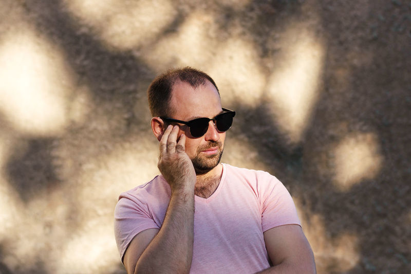 Portrait of young man wearing sunglasses standing outdoors