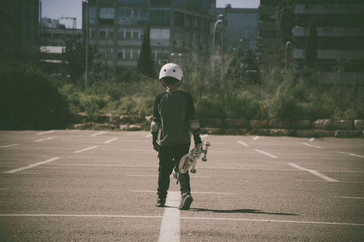 Rear view of boy with skateboard