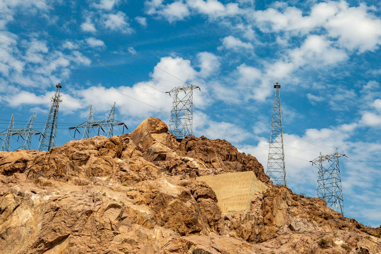 Looking up at electricity pylons on a rocky landscape, near the hoover dam