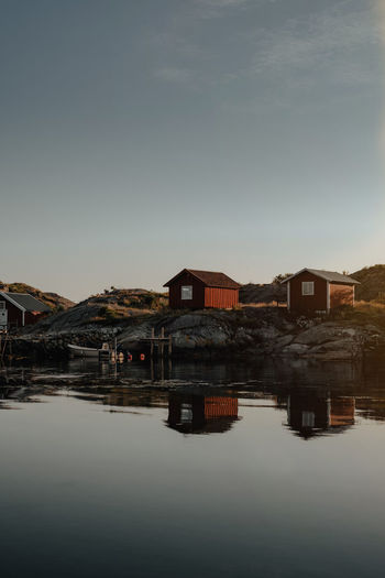 Buildings by lake against clear sky