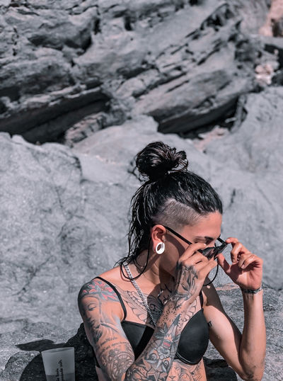 Young woman with tattoos photographing camera