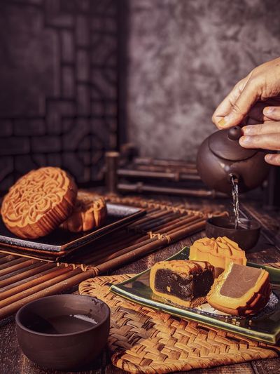 Cropped hand of person preparing food on table
