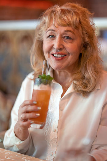 Portrait of a smiling young woman holding drink
