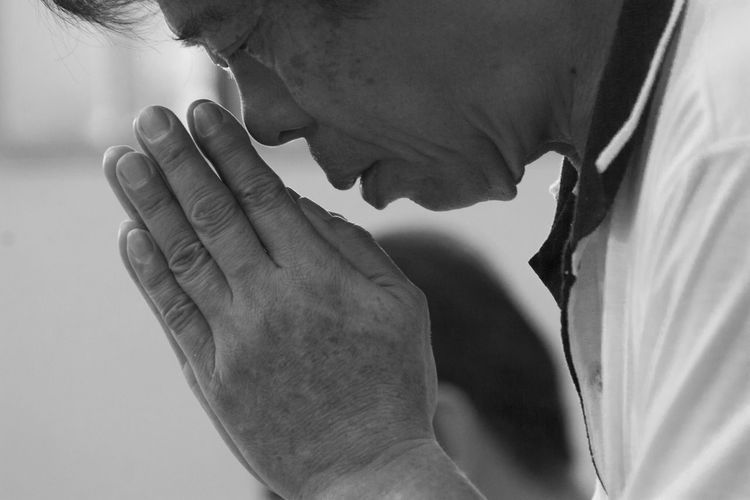 Close-up of senior man praying