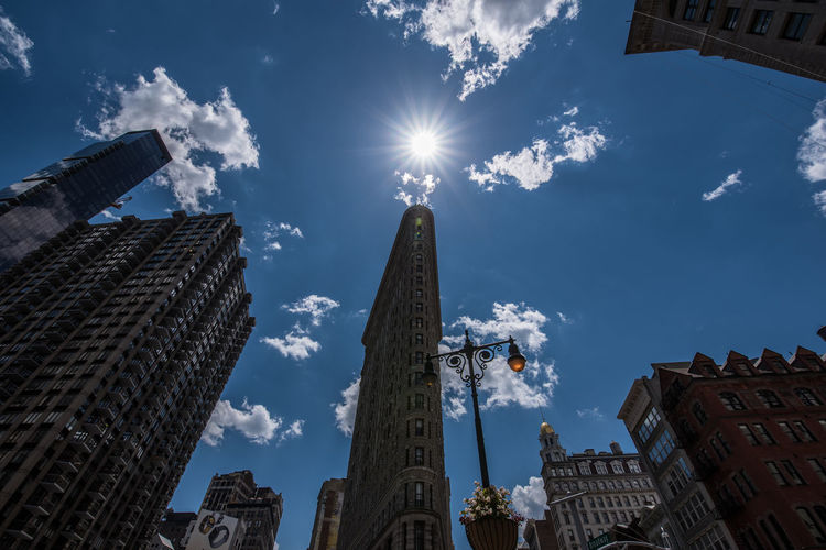 Low angle view of flatiron building against sky on sunny day