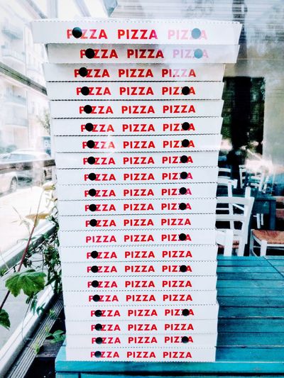 Close-up of pizza boxes waiting for delivery in building